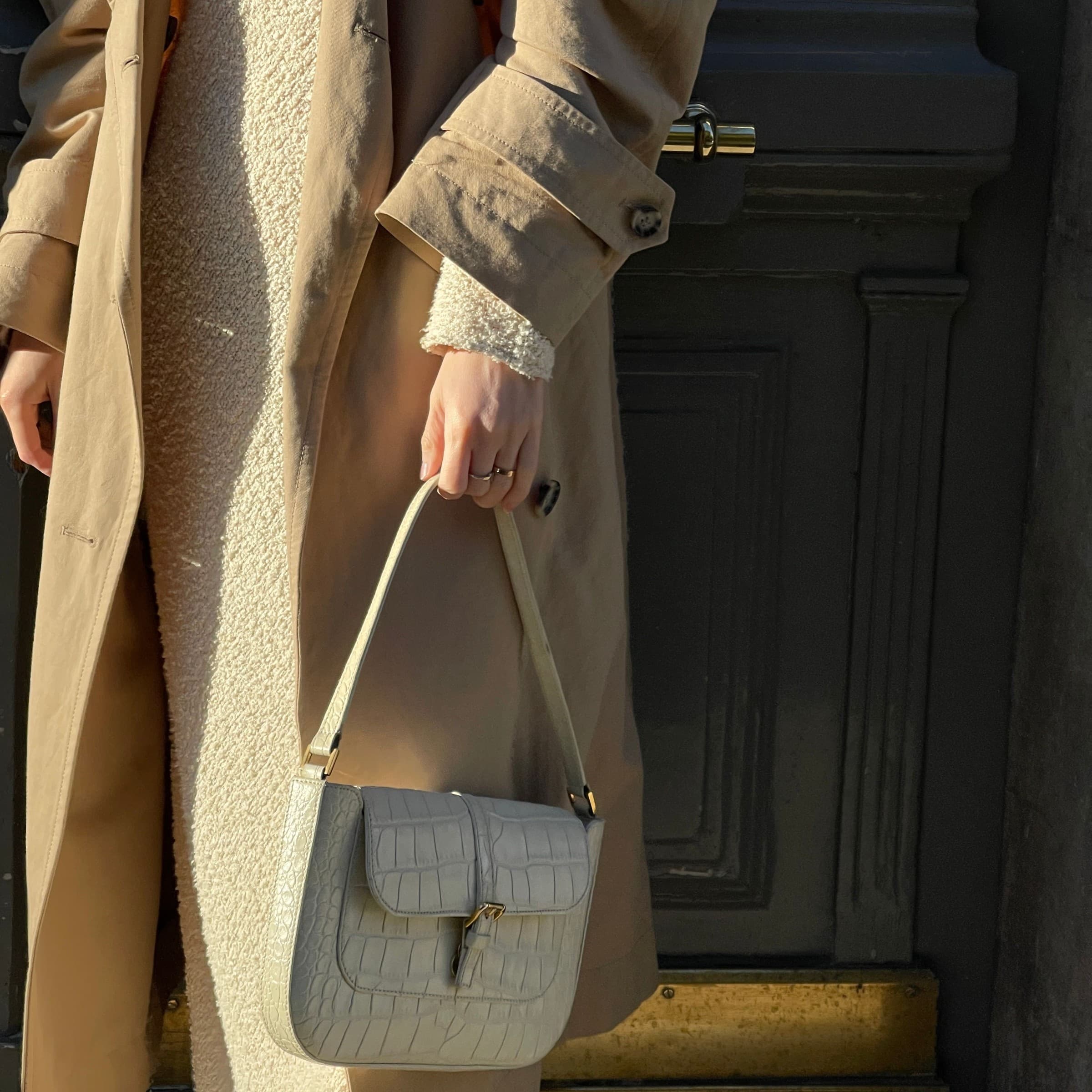 Classic neutral layering with a textured knit, trench coat, and structured mini bag.